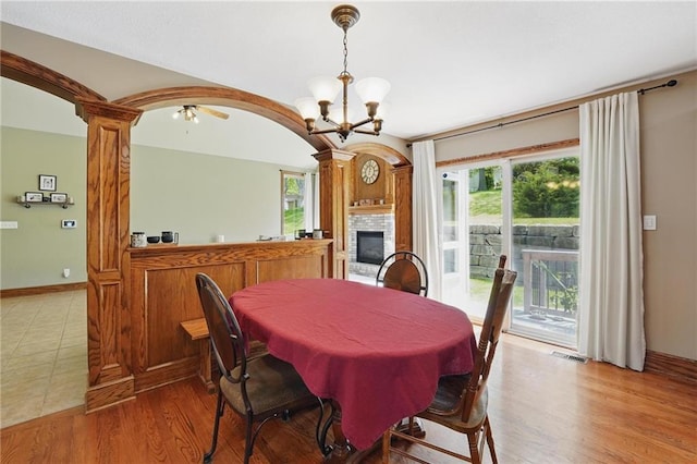 22721 E 27th Street Ct S, Blue Springs, MO 64015 - dining room with a chandelier, ornate columns, a glass covered fireplace, light wood-type flooring, and arched walkways