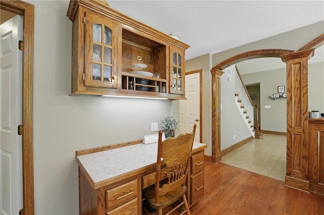 22721 E 27th Street Ct S, Blue Springs, MO 64015 - dining area with arched walkways, decorative columns, light wood finished floors, stairway, and an office area