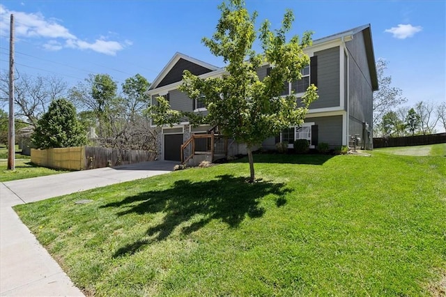 view of front of property featuring fence, driveway, a front yard, and a garage
