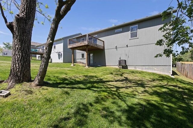 rear view of property with central AC, a yard, a deck, and fence