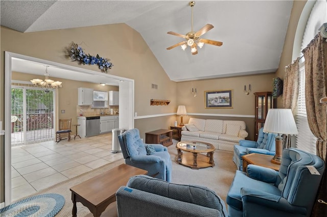 living area with ceiling fan with notable chandelier, light tile patterned flooring, and high vaulted ceiling