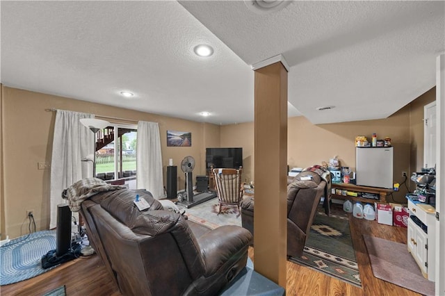 living area with recessed lighting, a textured ceiling, and wood finished floors