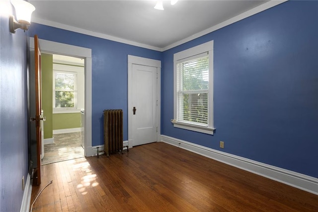 3700 Jefferson St, Kansas City, MO 64111 - unfurnished bedroom with radiator heating unit, hardwood / wood-style floors, multiple windows, ornamental molding, and baseboards