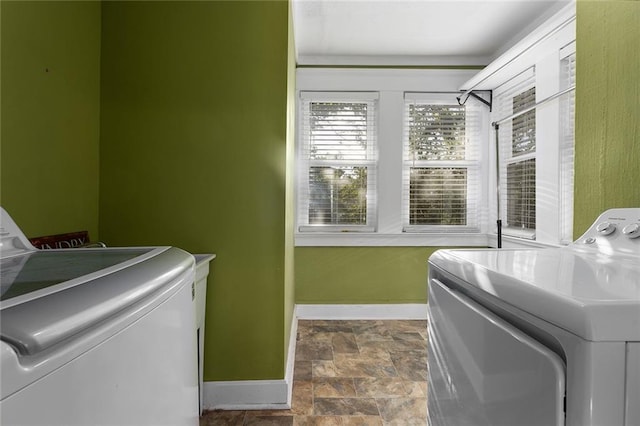3700 Jefferson St, Kansas City, MO 64111 - laundry area with baseboards, washer and dryer, and stone finish floors