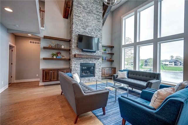 18 Black Hawk Dr, Lake Winnebago, MO 64034 - living area featuring a high ceiling, plenty of natural light, light wood-style flooring, baseboards, and a fireplace