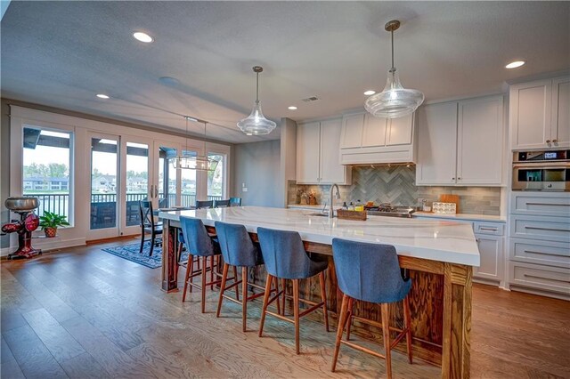 18 Black Hawk Dr, Lake Winnebago, MO 64034 - kitchen with oven, tasteful backsplash, wood finished floors, recessed lighting, and white cabinets