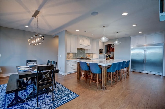 18 Black Hawk Dr, Lake Winnebago, MO 64034 - kitchen featuring appliances with stainless steel finishes, premium range hood, recessed lighting, dark wood-style floors, and decorative backsplash