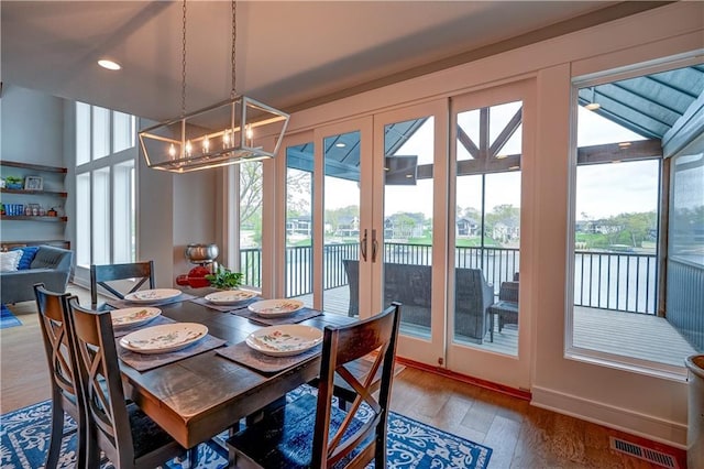 18 Black Hawk Dr, Lake Winnebago, MO 64034 - dining area featuring french doors, a water view, wood finished floors, a chandelier, and recessed lighting