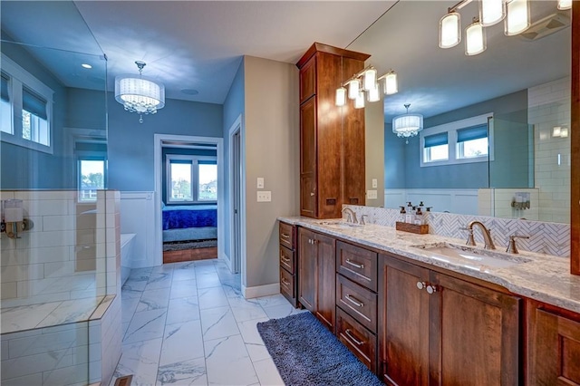 18 Black Hawk Dr, Lake Winnebago, MO 64034 - full bathroom featuring a chandelier, a bathtub, double vanity, and marble look tile flooring