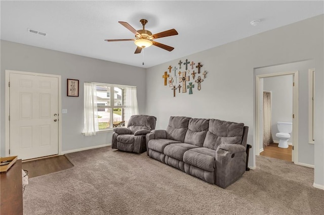 carpeted living room featuring visible vents, a ceiling fan, and baseboards