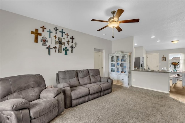 carpeted living area featuring a ceiling fan
