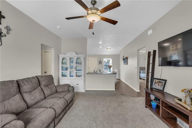 living area with carpet floors, ceiling fan, and baseboards