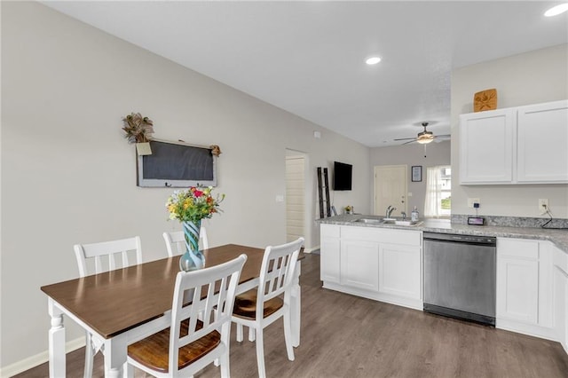 kitchen with ceiling fan, dishwasher, a sink, white cabinets, and a peninsula