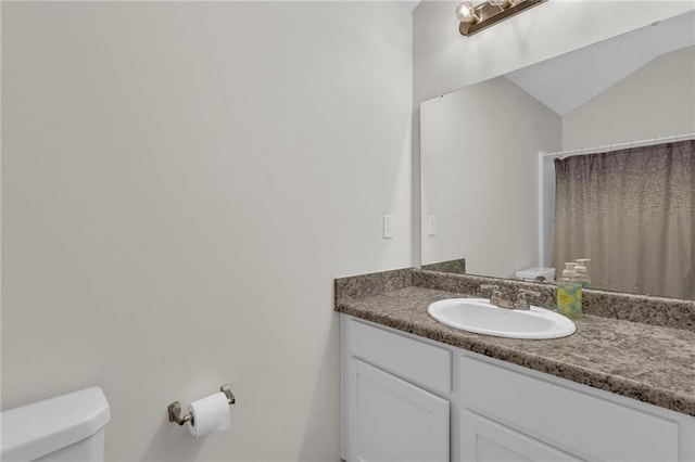 full bath featuring vanity, toilet, and lofted ceiling