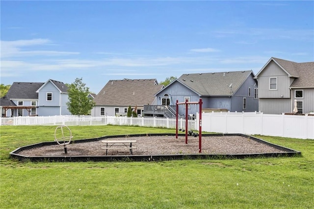 view of playground with a residential view, fence, and a lawn