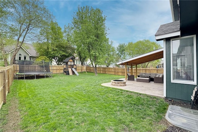 4200 Grand Ave, Leavenworth, KS 66048 - view of yard with an outdoor living space with a fire pit, a patio, a fenced backyard, a playground, and a trampoline