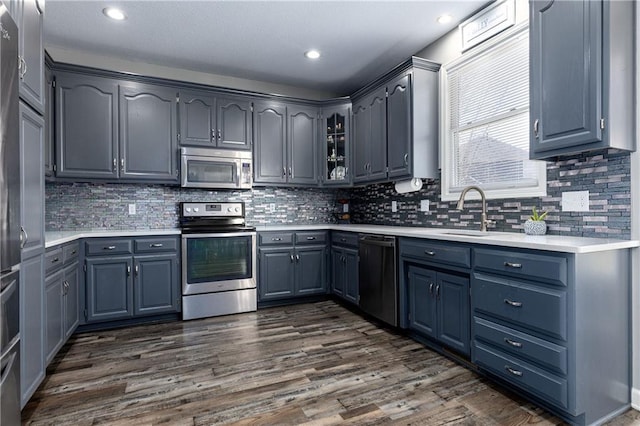 4200 Grand Ave, Leavenworth, KS 66048 - kitchen featuring tasteful backsplash, a sink, light countertops, dark wood-style floors, and stainless steel appliances