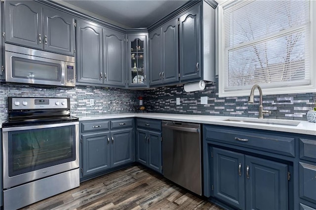 4200 Grand Ave, Leavenworth, KS 66048 - kitchen featuring dark wood-style flooring, light countertops, tasteful backsplash, a sink, and appliances with stainless steel finishes
