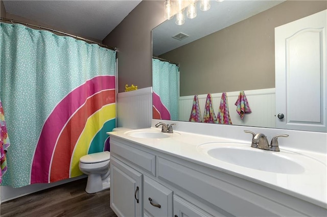 4200 Grand Ave, Leavenworth, KS 66048 - full bath featuring a sink, double vanity, wainscoting, and wood finished floors