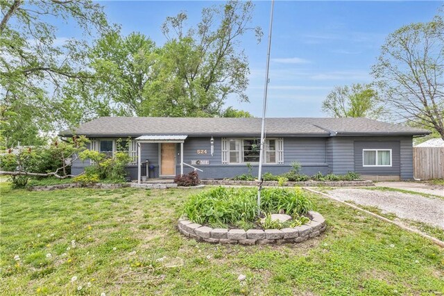 ranch-style home featuring fence and a front yard