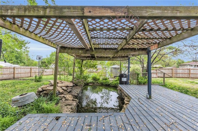wooden deck with a fenced backyard, a pergola, and a yard