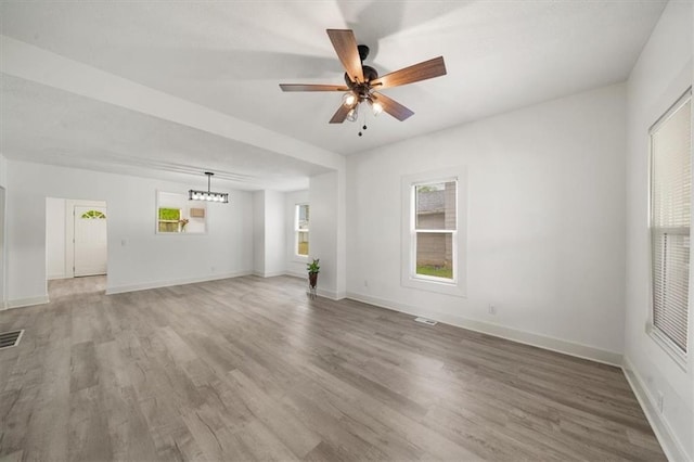 507 N Pearl St, Paola, KS 66071 - unfurnished living room with plenty of natural light, baseboards, ceiling fan, and light wood-style flooring