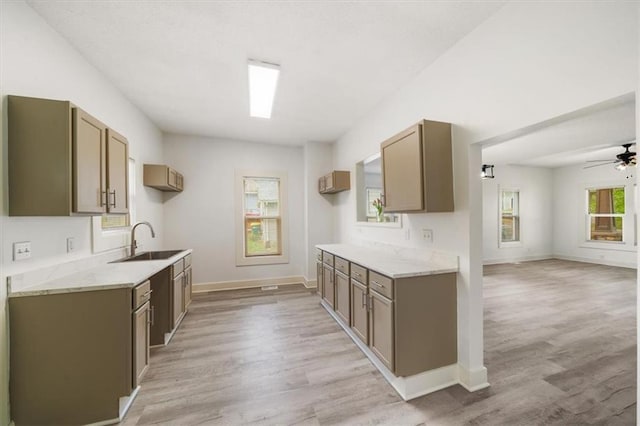 507 N Pearl St, Paola, KS 66071 - kitchen featuring a ceiling fan, a sink, baseboards, open floor plan, and light wood-style flooring