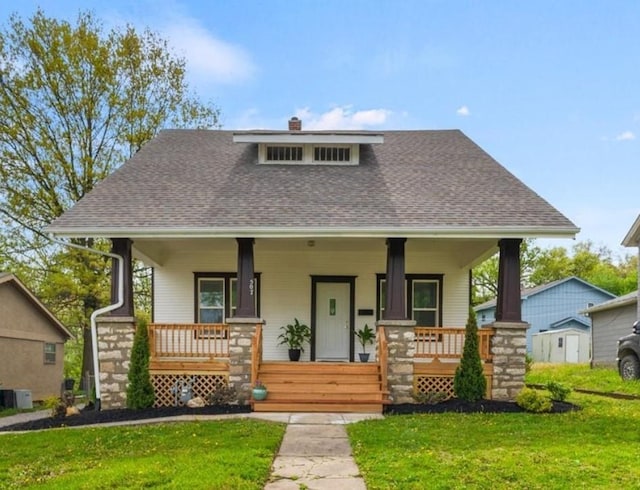 507 N Pearl St, Paola, KS 66071 - bungalow featuring a chimney, a shingled roof, covered porch, and a front yard