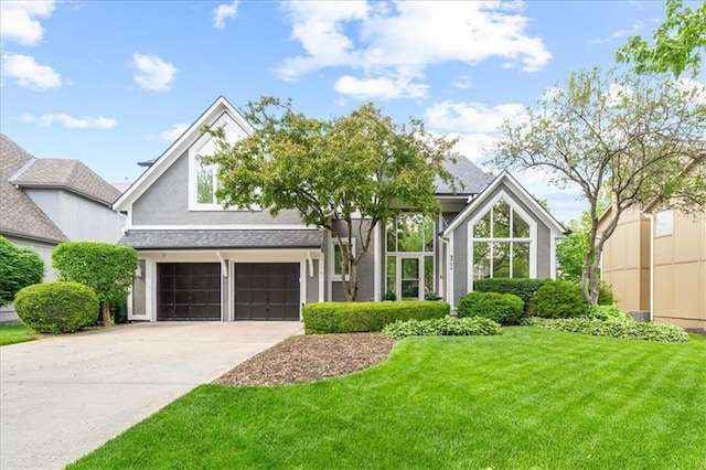 view of front of home featuring stucco siding, driveway, a front lawn, and a garage