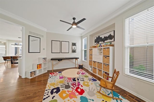 rec room featuring visible vents, crown molding, wood finished floors, and a healthy amount of sunlight