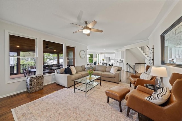 living room with ceiling fan, wood finished floors, and a healthy amount of sunlight