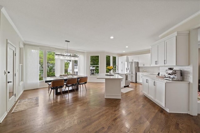 kitchen with a center island, ornamental molding, appliances with stainless steel finishes, and a wealth of natural light