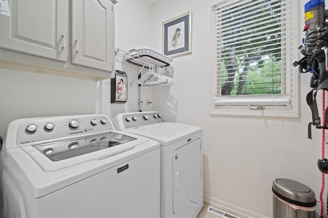 laundry area featuring baseboards, washer and clothes dryer, cabinet space, and visible vents