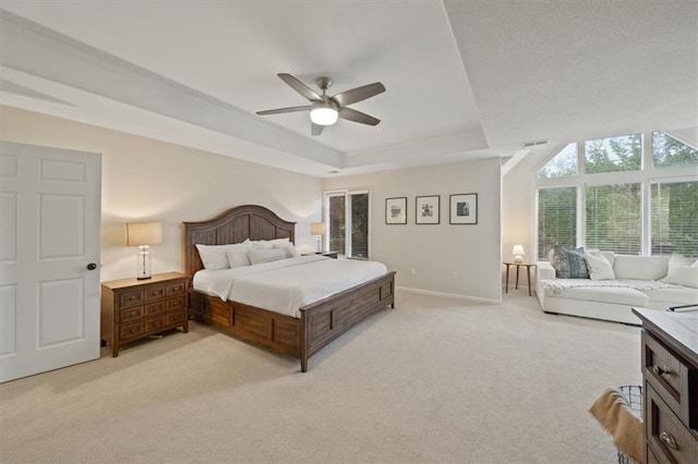 bedroom featuring light colored carpet, a ceiling fan, baseboards, a tray ceiling, and visible vents
