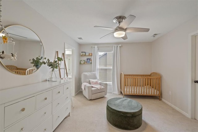 bedroom featuring a nursery area, light carpet, a ceiling fan, baseboards, and visible vents
