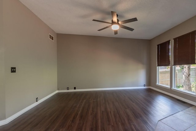 6512 N Fisk Ct, Kansas City, MO 64151 - empty room featuring a ceiling fan, dark wood-style floors, baseboards, and a textured ceiling