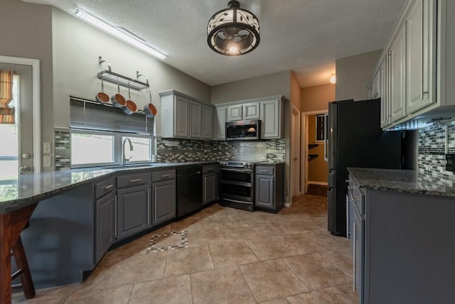 6512 N Fisk Ct, Kansas City, MO 64151 - kitchen with gray cabinets, stainless steel appliances, a sink, decorative backsplash, and a textured ceiling