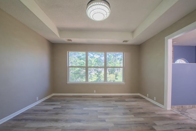 6512 N Fisk Ct, Kansas City, MO 64151 - spare room featuring a tray ceiling, wood finished floors, and baseboards