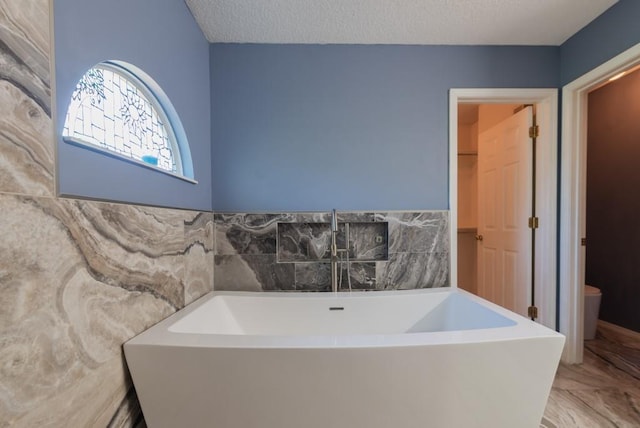 6512 N Fisk Ct, Kansas City, MO 64151 - full bathroom featuring a soaking tub, marble finish floors, and toilet