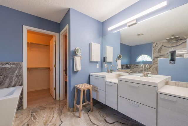 6512 N Fisk Ct, Kansas City, MO 64151 - full bathroom featuring a garden tub, marble finish floors, vanity, a walk in closet, and tile walls
