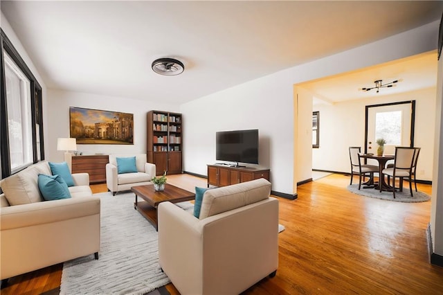 living area with baseboards and wood finished floors
