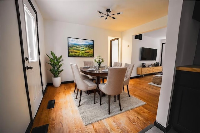 dining space featuring visible vents, baseboards, and light wood-type flooring