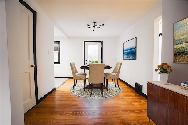 dining room featuring baseboards and light wood finished floors