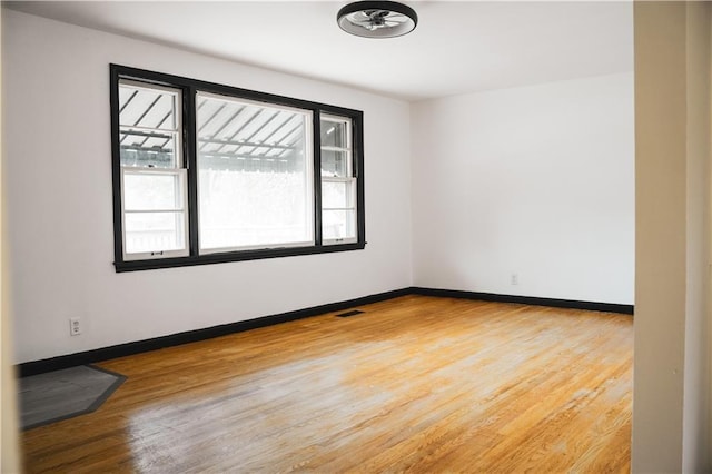 empty room with baseboards, light wood-style flooring, and visible vents