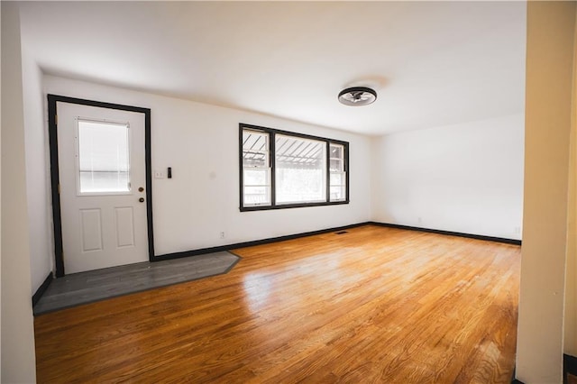 foyer entrance with baseboards and wood finished floors