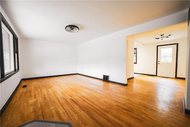 spare room featuring visible vents, baseboards, and wood finished floors