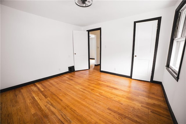 unfurnished bedroom with baseboards and light wood-type flooring