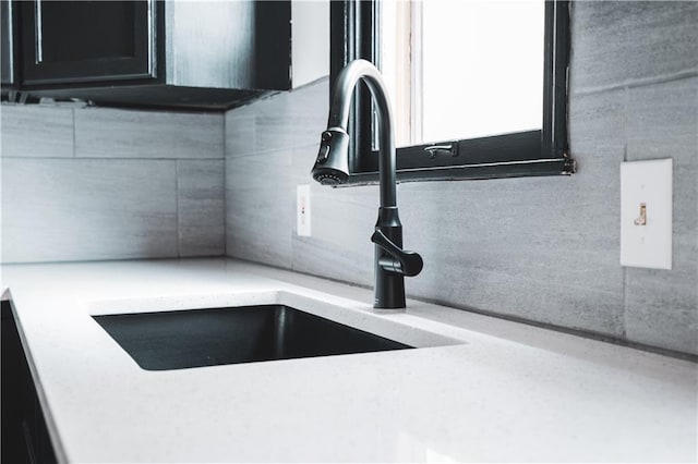room details featuring backsplash, a sink, and light countertops
