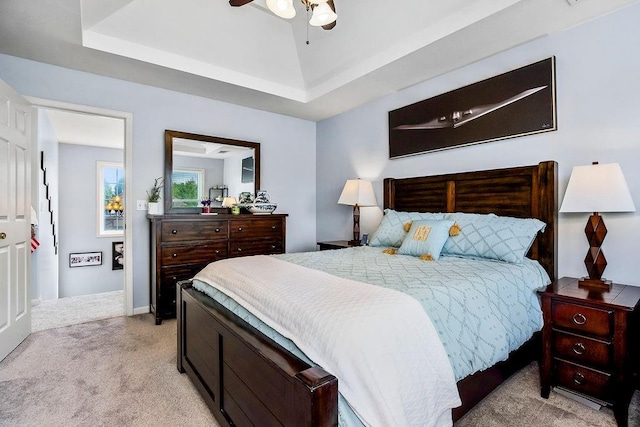 1024 Tamarisk Dr, Leavenworth, KS 66048 - bedroom with light colored carpet, a raised ceiling, and a ceiling fan