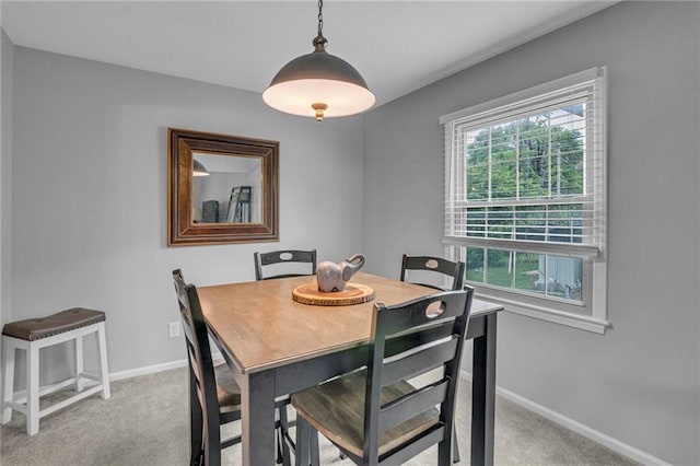 dining area featuring light carpet and baseboards